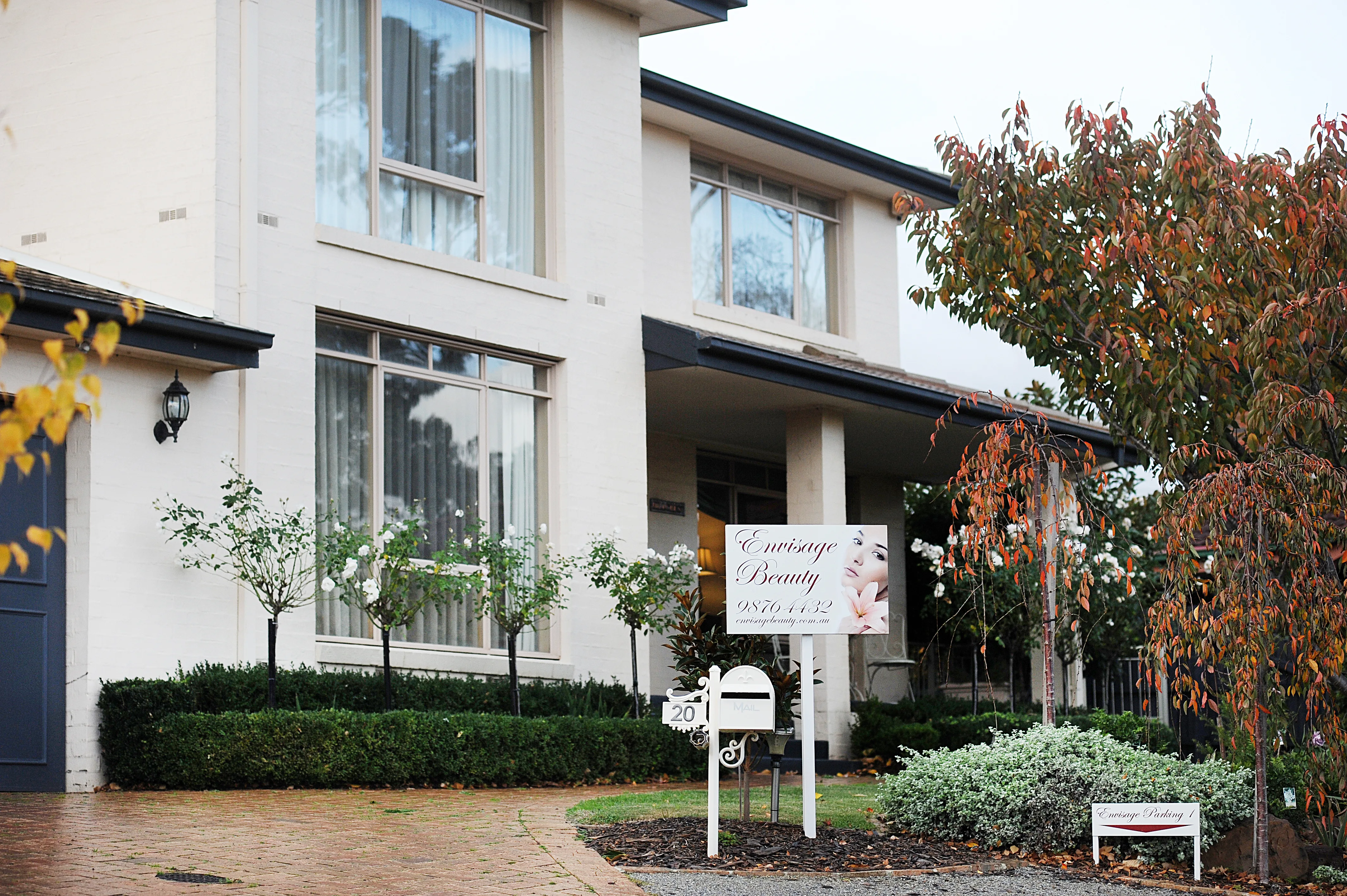 Exterior of the Envisage Beauty home salon in Ringwood North with garden and salon signage